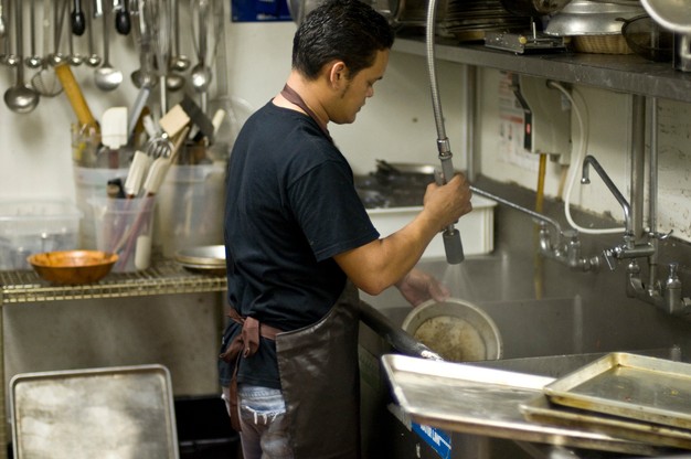 man washes dishes at a restaurant