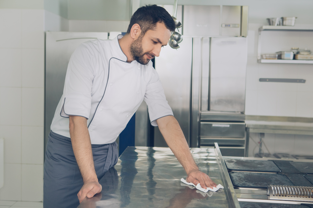 man maintains equipment in restaurant