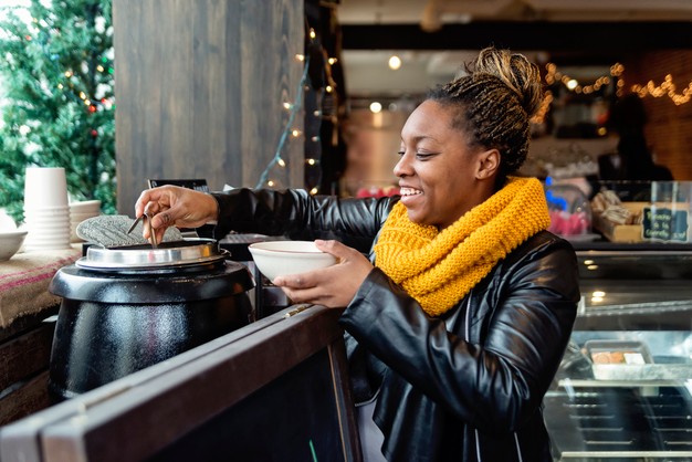 happy woman serving herself soup